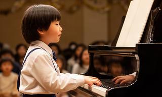 音楽教室の発表会でピアノを演奏する小学生