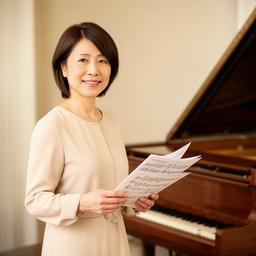 ピアノ講師の西村彩香がグランドピアノの前で楽譜を手にする様子